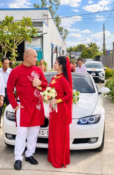 Thuê xe mui trần cưới BMW 3 Series mui trần trắng – cặp đôi áo dài đỏ bên xe